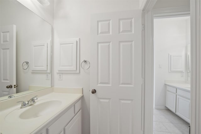 bathroom with vanity, baseboards, and tile patterned flooring