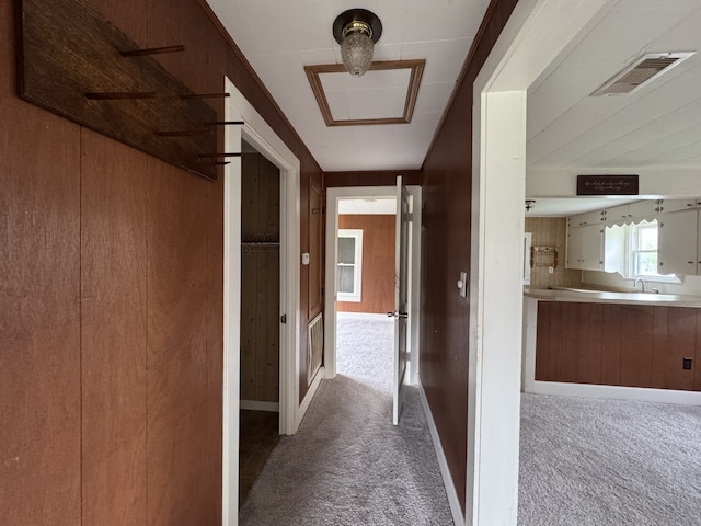 corridor with visible vents, a sink, and carpet