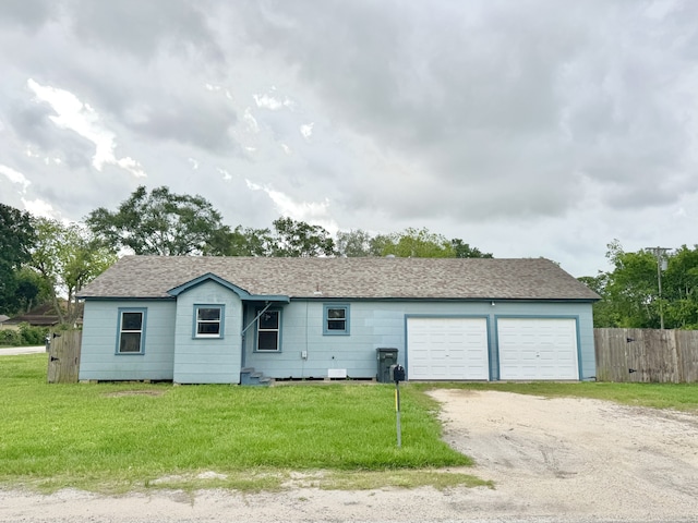 view of front facade featuring an attached garage, fence, driveway, and a front yard