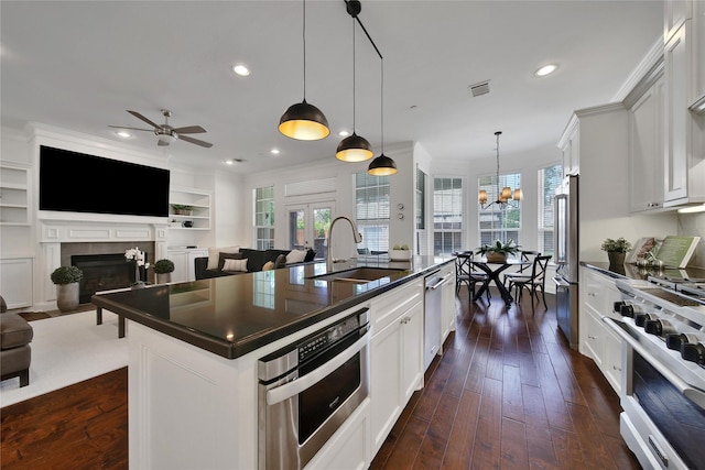 8322 Merlin Dr, Spring Valley Village, TX 77055 - kitchen with a sink, dark countertops, high quality appliances, a fireplace with flush hearth, and recessed lighting