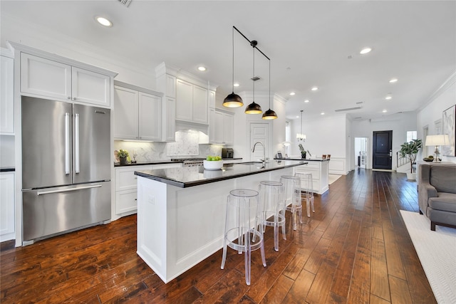 8322 Merlin Dr, Spring Valley Village, TX 77055 - kitchen featuring high quality fridge, dark countertops, open floor plan, an island with sink, and a sink