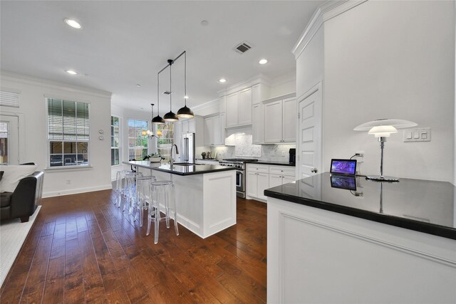 8322 Merlin Dr, Spring Valley Village, TX 77055 - kitchen with dark countertops, ornamental molding, backsplash, a kitchen breakfast bar, and dark wood-style floors