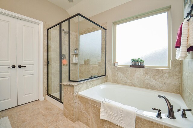 full bath featuring tile patterned floors, a stall shower, and a garden tub
