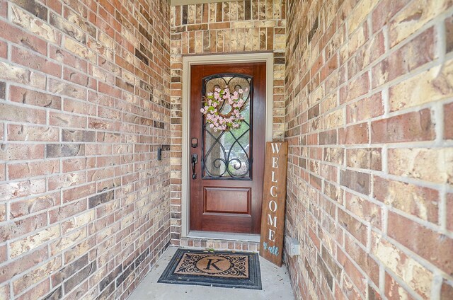 doorway to property featuring brick siding