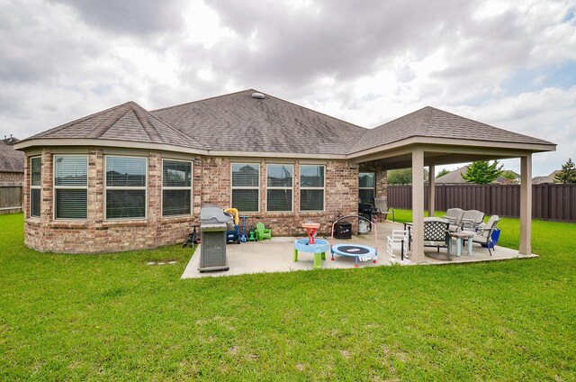 rear view of property featuring a fenced backyard, a patio, and brick siding