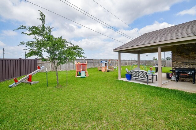 view of yard with a patio, a fenced backyard, and a playground