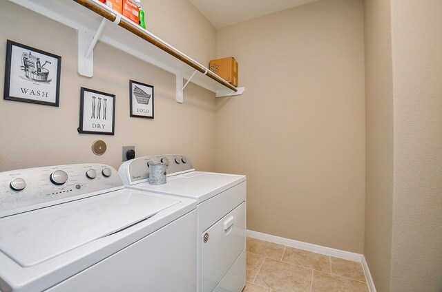 laundry room featuring light tile patterned floors, baseboards, laundry area, and washer and clothes dryer
