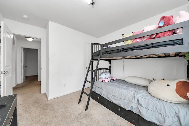 bedroom featuring light colored carpet and baseboards