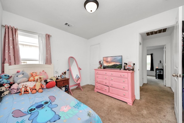 bedroom with visible vents and light carpet