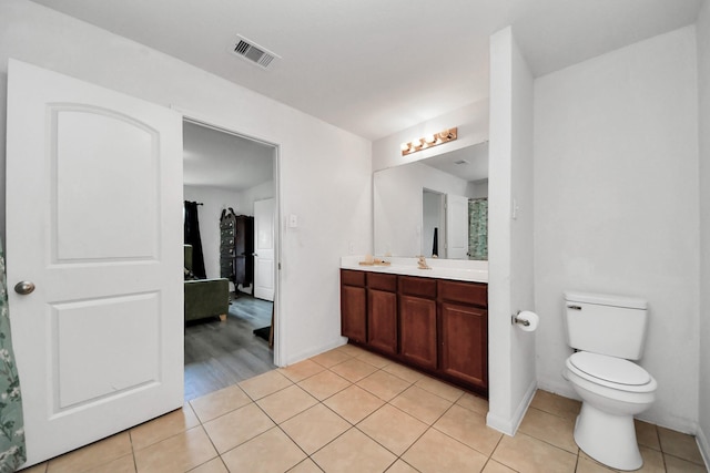 bathroom featuring double vanity, tile patterned flooring, toilet, and visible vents