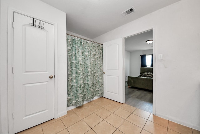 bathroom featuring baseboards, tile patterned floors, visible vents, and curtained shower
