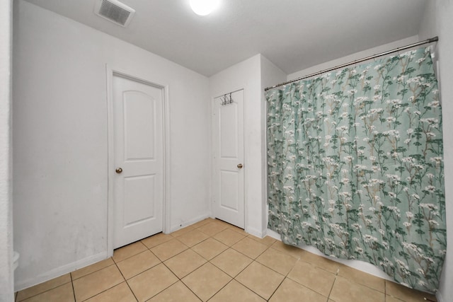 spare room with baseboards, visible vents, and light tile patterned floors