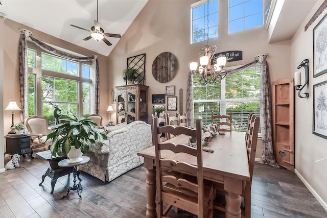 dining room with baseboards, dark wood-style flooring, ceiling fan with notable chandelier, and high vaulted ceiling