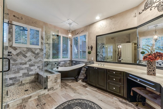 bathroom featuring vanity, a freestanding tub, a stall shower, and tile walls