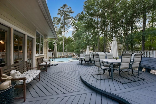 wooden deck featuring a fenced in pool, outdoor dining area, and a fenced backyard