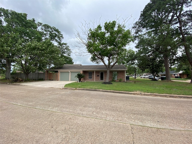 ranch-style house featuring fence, a front lawn, brick siding, a garage, and driveway