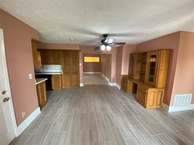 unfurnished living room with a textured ceiling, ceiling fan, visible vents, and baseboards