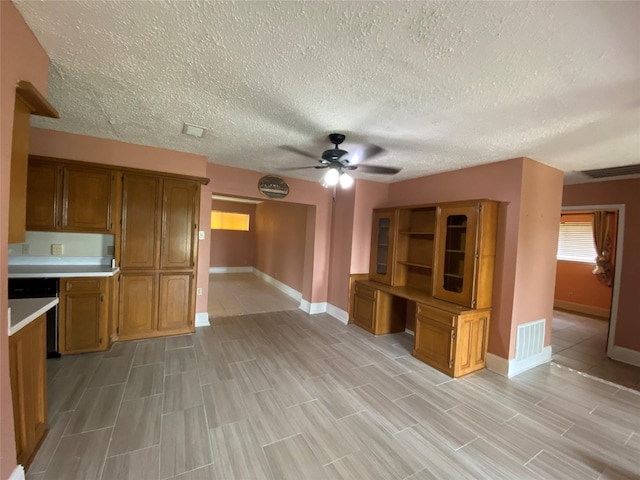 kitchen with brown cabinets, ceiling fan, and baseboards