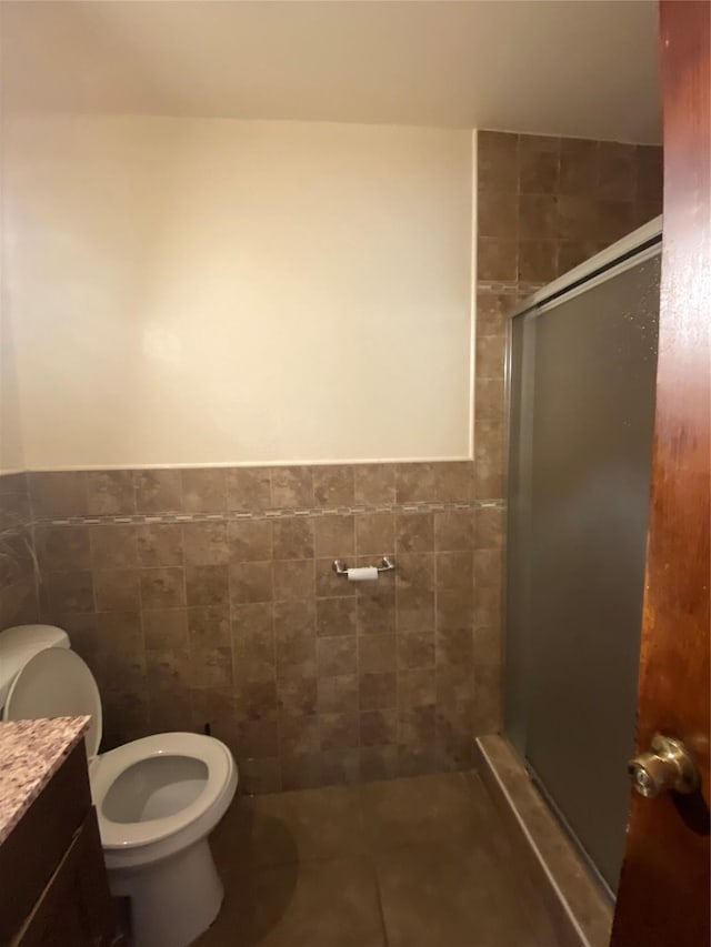 full bath with tile patterned floors, a shower stall, toilet, and tile walls