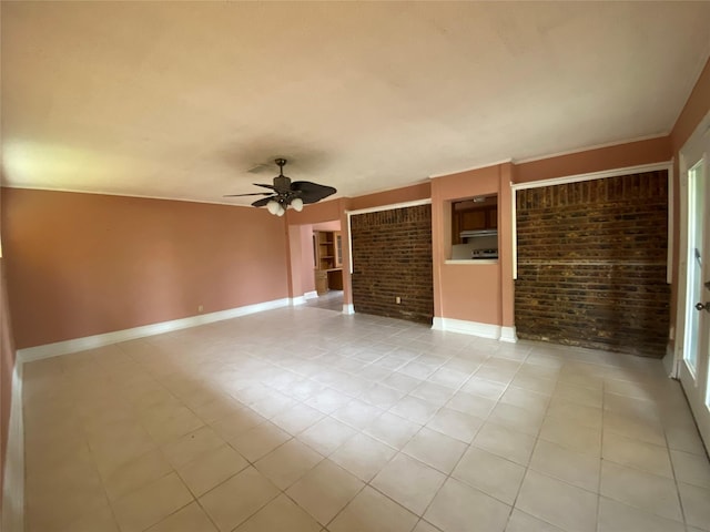 spare room with light tile patterned flooring, ceiling fan, baseboards, and brick wall