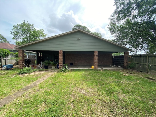 back of house with a yard, brick siding, and fence