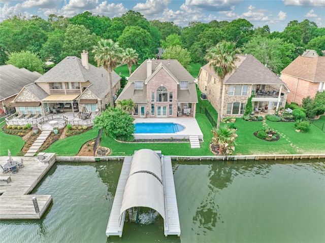 back of house with a water view, a patio area, an outdoor pool, and a balcony