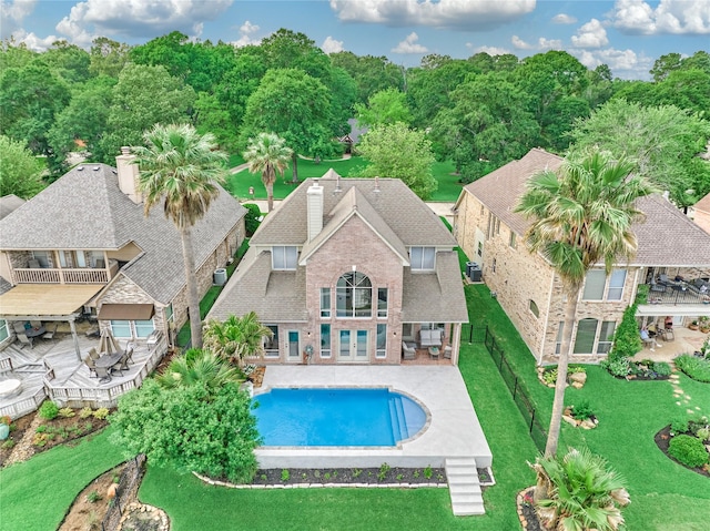 outdoor pool with a lawn, a fenced backyard, a patio area, and french doors