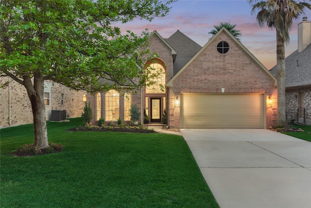 view of front of property with brick siding, an attached garage, a front yard, and concrete driveway