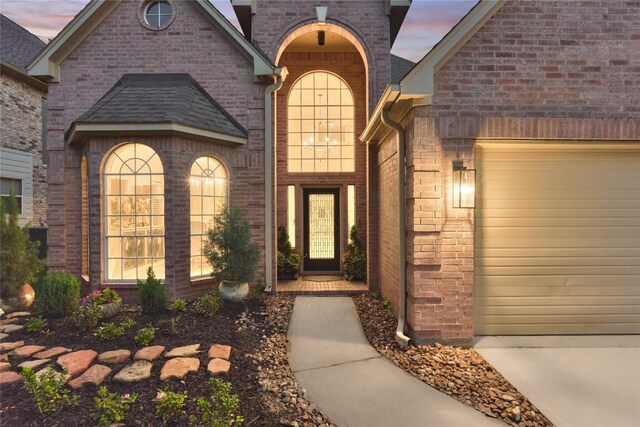 2025 S Shore Blvd, Montgomery, TX 77356 - doorway to property featuring a garage, concrete driveway, and brick siding