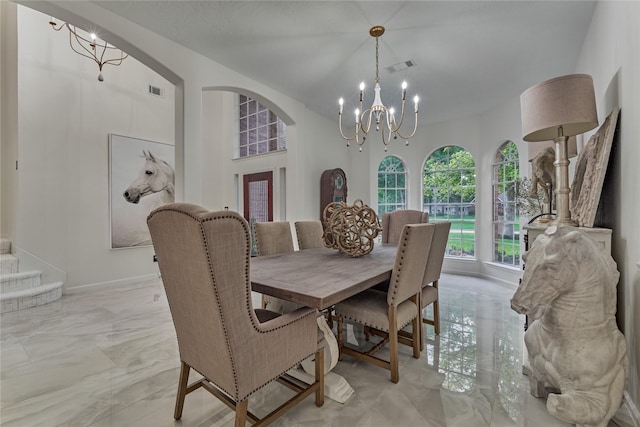 dining room featuring marble finish floor, arched walkways, a chandelier, and visible vents