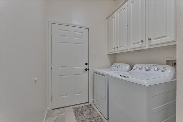 laundry room featuring baseboards, cabinet space, and independent washer and dryer