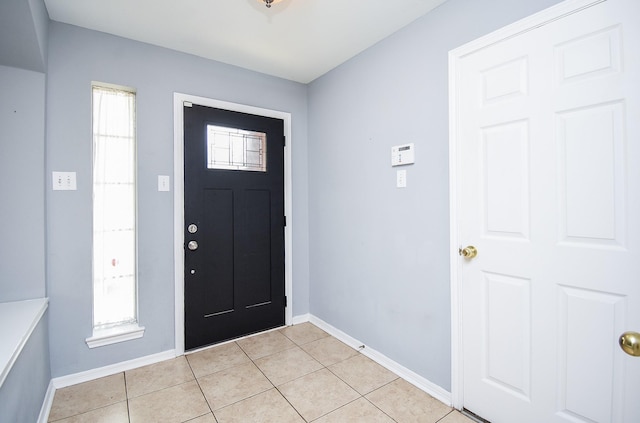entryway with baseboards and light tile patterned floors