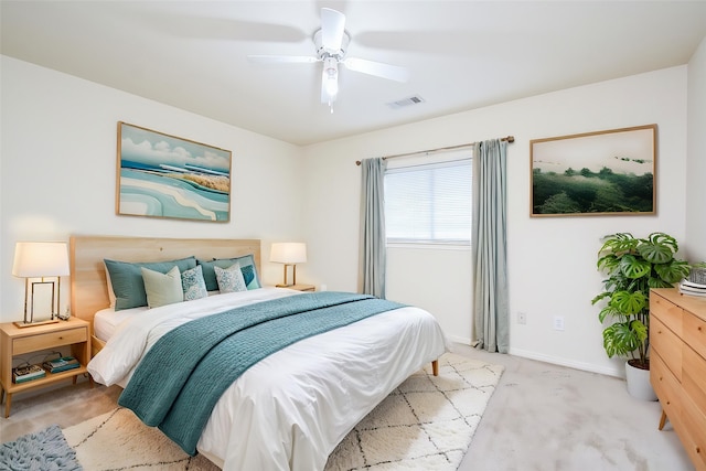 bedroom with visible vents, a ceiling fan, baseboards, and light colored carpet