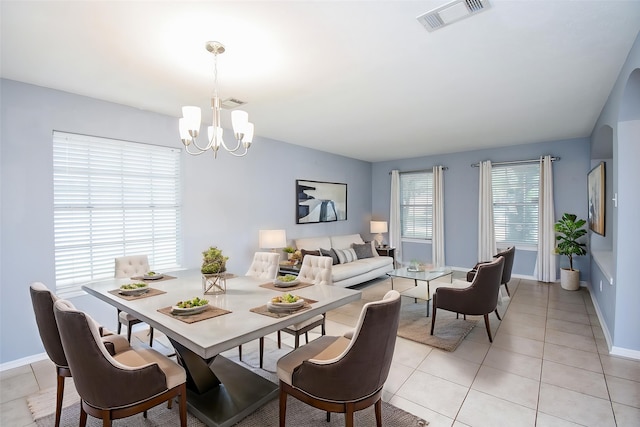dining space featuring baseboards, a notable chandelier, visible vents, and light tile patterned floors