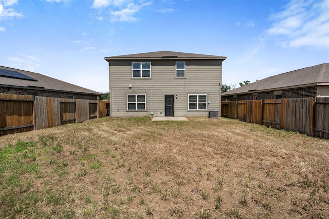 back of property with a yard, cooling unit, and a fenced backyard