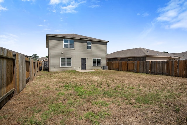 back of house with central air condition unit, a lawn, and a fenced backyard