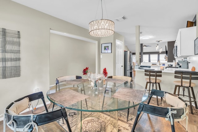 9114 Colony Cove Dr, Spring, TX 77379 - dining area featuring baseboards, a notable chandelier, light wood-style flooring, and visible vents