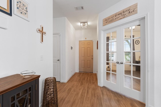 entryway with light wood-style floors, baseboards, french doors, and visible vents