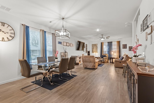 dining area featuring light wood-style floors, baseboards, visible vents, and a healthy amount of sunlight