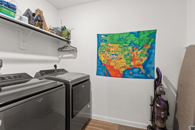 laundry room with washer and dryer, laundry area, baseboards, and wood finished floors