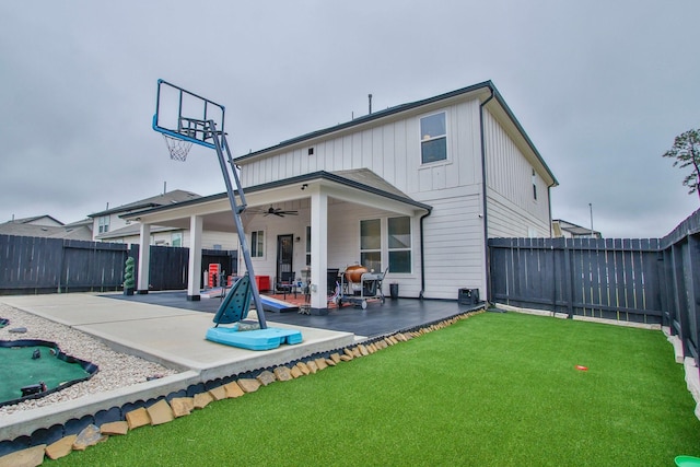 back of property featuring a ceiling fan, a patio area, a fenced backyard, and a yard