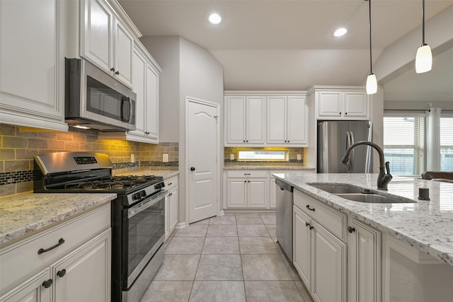 kitchen featuring white cabinets, stainless steel appliances, a sink, and backsplash