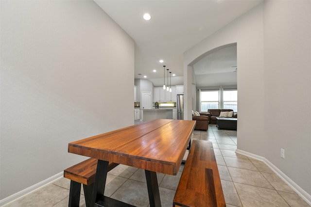 dining space featuring arched walkways, baseboards, recessed lighting, and light tile patterned flooring
