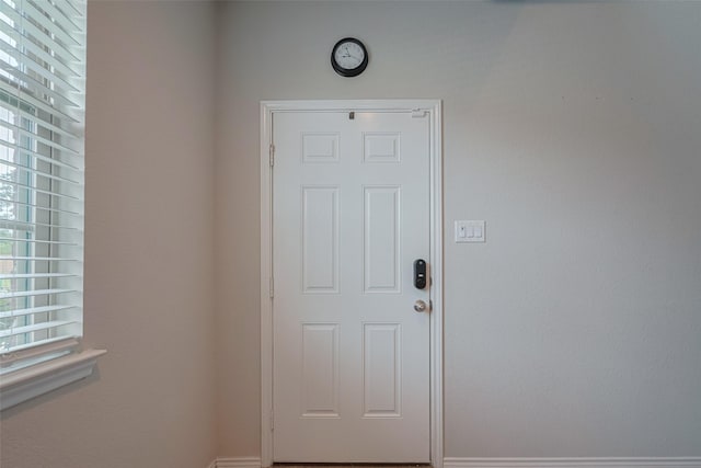doorway to outside featuring baseboards