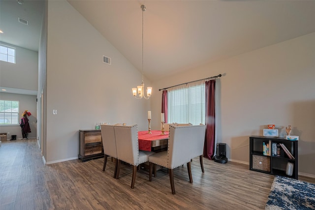 dining space featuring high vaulted ceiling, a chandelier, and wood finished floors