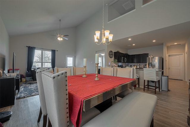 dining room featuring recessed lighting, high vaulted ceiling, wood finished floors, and ceiling fan with notable chandelier