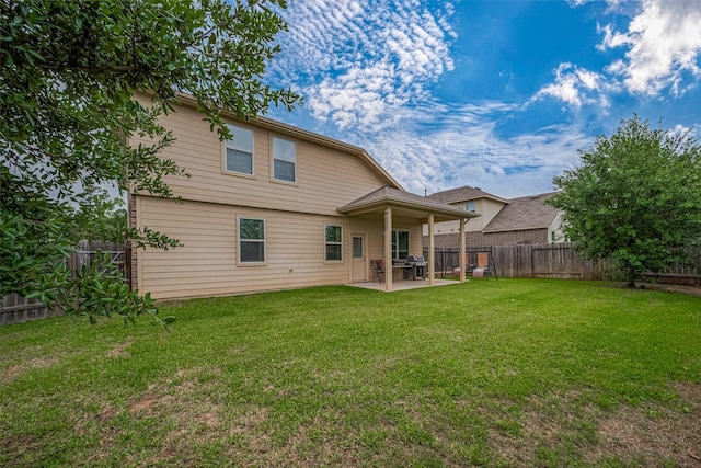 back of property with a lawn, a patio, and a fenced backyard