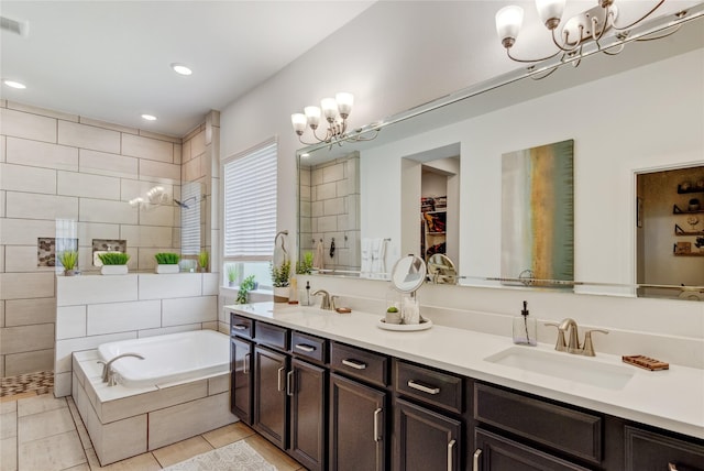 full bath featuring an inviting chandelier, a sink, a garden tub, and tile patterned floors