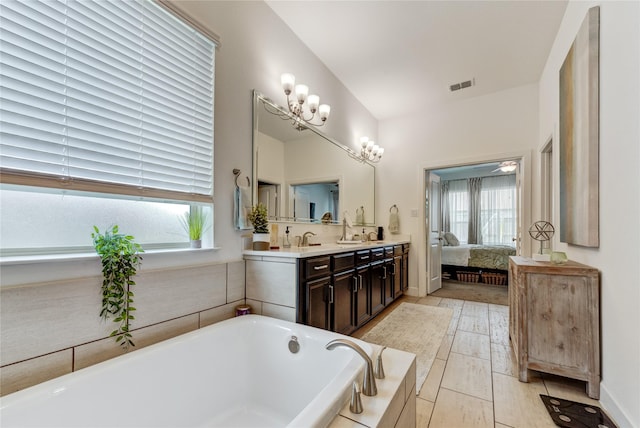 full bathroom featuring double vanity, a washtub, visible vents, a sink, and ensuite bathroom
