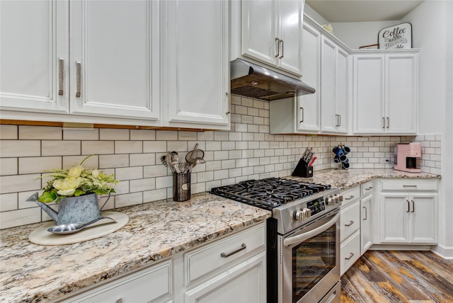 kitchen featuring stainless steel range with gas stovetop, white cabinetry, backsplash, wood finished floors, and under cabinet range hood
